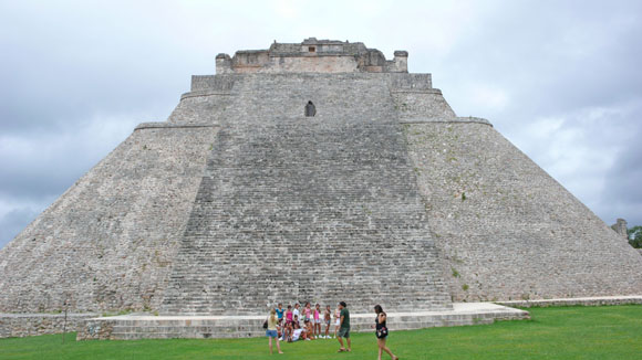 Tourists explore the Temple of the Magician at Uxmal